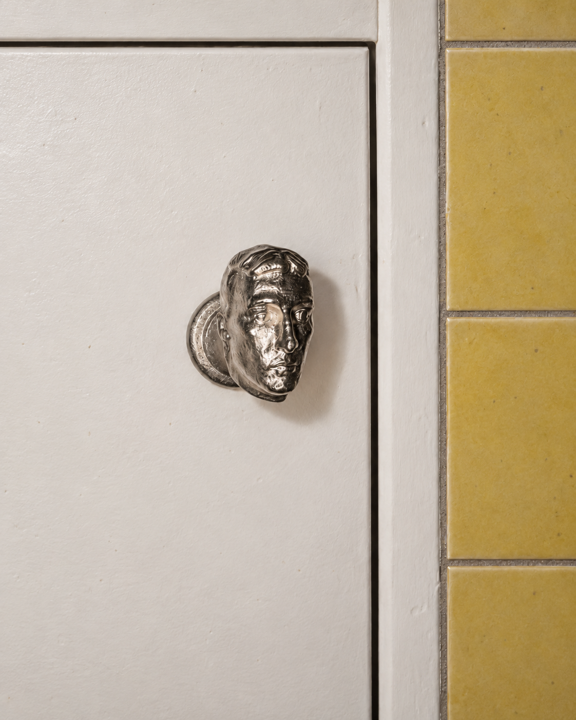 Human-head cabinet knob on a kitchen cabinet