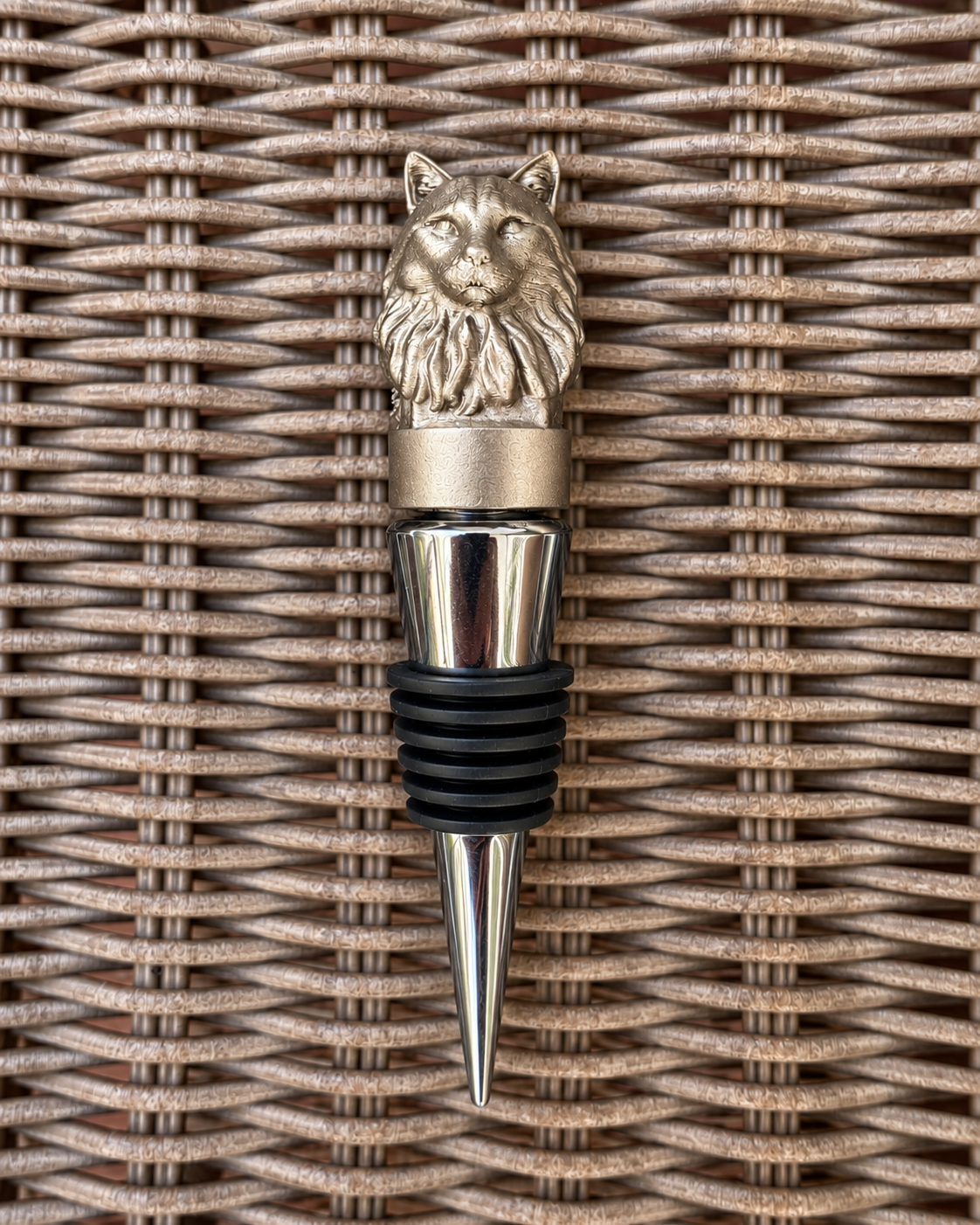 Cat wine bottle stopper on a wicker surface